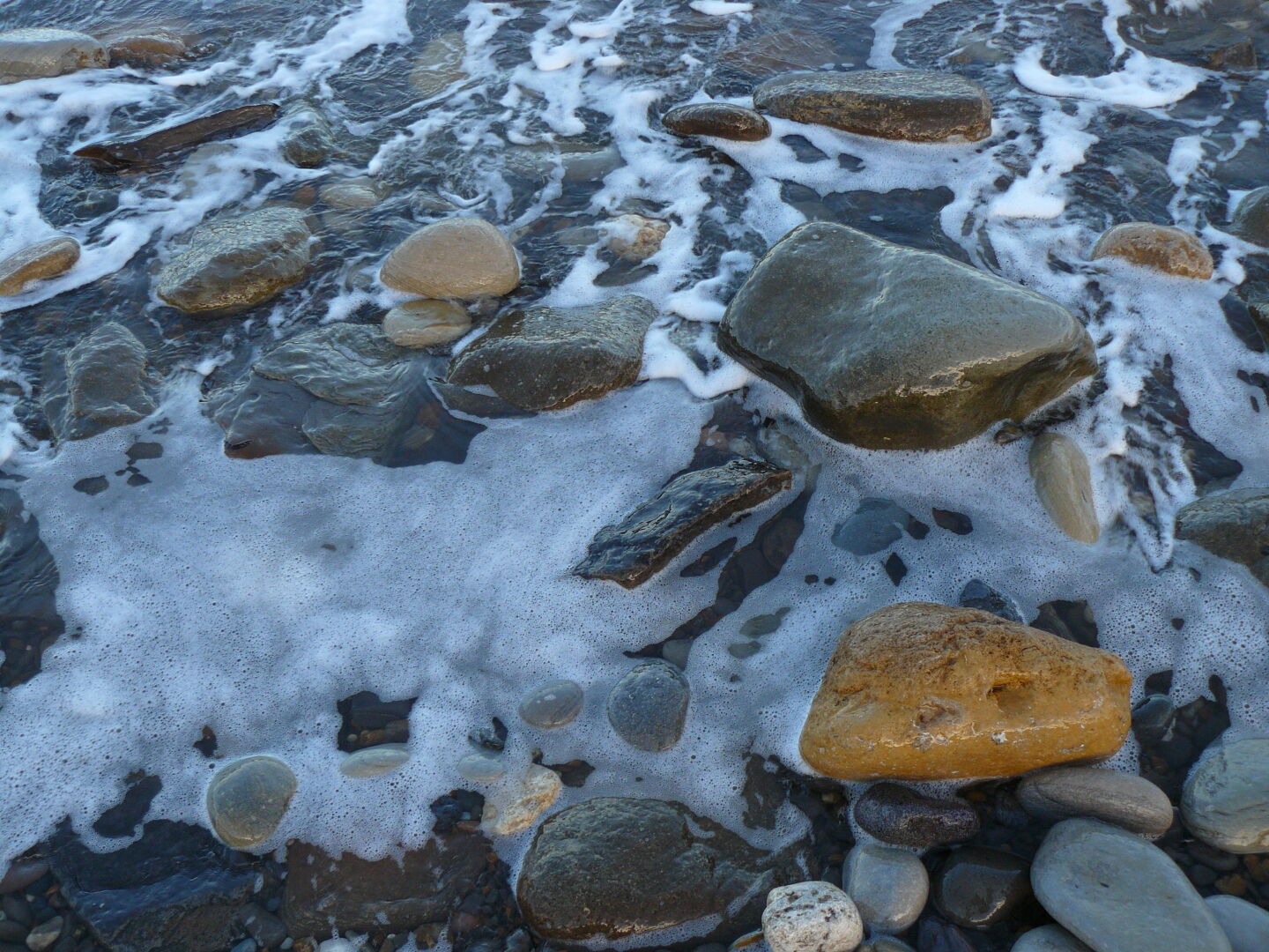The tide rushes in, black water gurgling around the rocks...