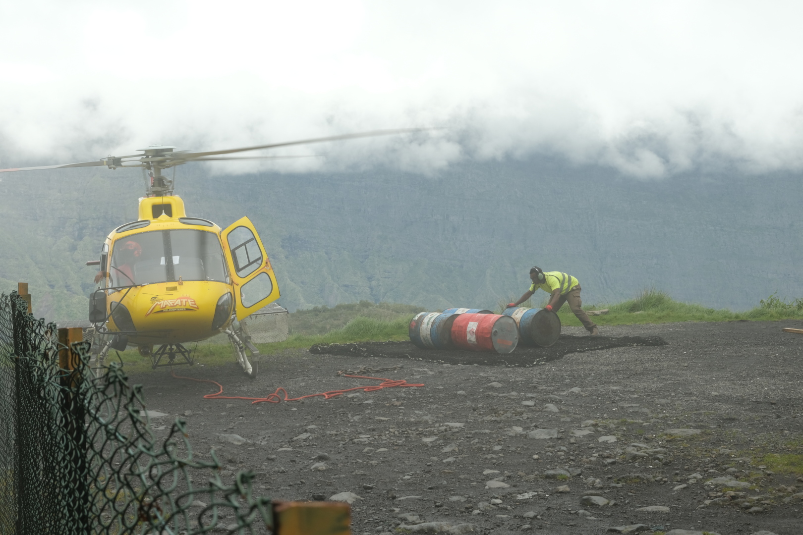Der Hubschrauber vom Typ H125 Écureuil (Eichhörnchen) wird beladen. Er bringt vier Fässer Diesel nach Mafate hinein.